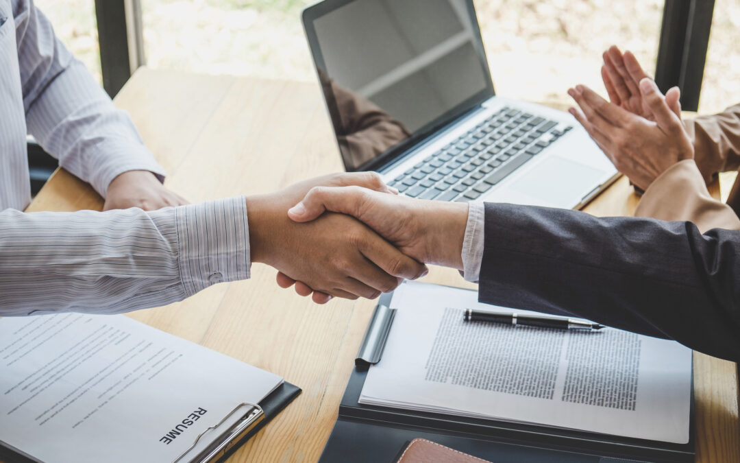 Greeting new colleagues, Handshake while job interviewing, male candidate shaking hands with Interviewer or employer after a job interview, employment and recruitment concept.